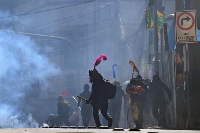 Demonstrators run amid tear gas smoke during a protest against the government of Bolivia's President Rodrigo Paz in La Paz on June 10, 2026. For weeks, protesters demanding that US-backed conservative President Rodrigo Paz's fledgling government address a deep economic crisis, while others called for his resignation, have marched and set up roadblocks, bringing Bolivia to a near standstill, driving up food and fuel prices and causing shortages of basic goods. (Photo by MARVIN RECINOS / AFP)