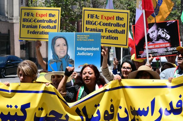 People march after a press conference held by the National Council of Resistance of Iran, which is calling on FIFA to suspend and expel the Iranian regime-controlled "Football Federation Islamic Republic of Iran" from international football, at Los Angeles City Hall, in Los Angeles, on June 10, 2026. (Photo by Frederic J. Brown / AFP)