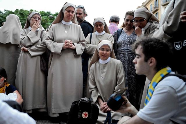 Nuns and people listen to the Holy Mass led by Pope Leo XIV outside of the Basilica of the Sagrada Familia in Barcelona, on June 10, 2026. Pope Leo XIV is visiting Spain June 6-12 with stops in Madrid, Barcelona, and the Canary Islands, where he will meet with migrants and organisations dedicated to helping them. (Photo by Ander Gillenea / AFP)