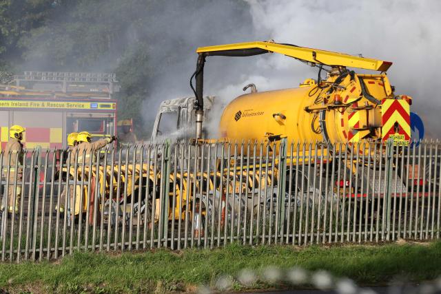 Emergency services work to put out a fire after an agricultural trailer was set alight as protesters gather near a hotel previously believed to house migrants in the town of Mallusk, Co Antrim, north of Belfast, Northern Ireland, on June 10, 2026. Northern Ireland braced on June 10 for a potential second night of violence directed at immigrants, following unrest that UK authorities say was stoked by far-right activists on social media after a brutal Belfast stabbing. (Photo by Paul Faith / AFP)