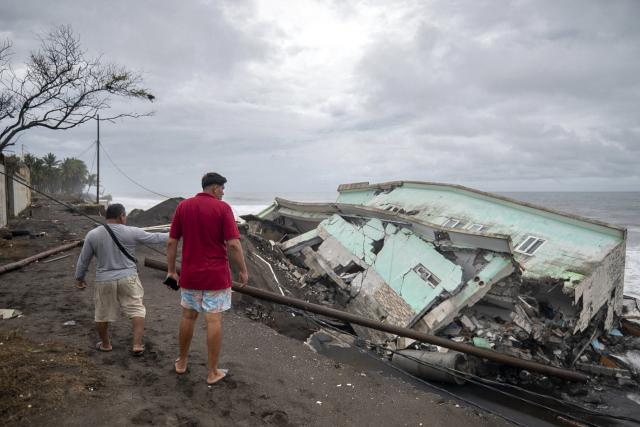 Men watch the damage caused by rough seas ahead of the arrival of Storm Cristina in Iztapa, Guatemala on June 10, 2026. The countries of Central America remain on alert over the effects of Tropical Storm Cristina, which formed on June 8, 2026 in the Pacific Ocean, civil protection services reported. (Photo by Carlos ALONZO / AFP)