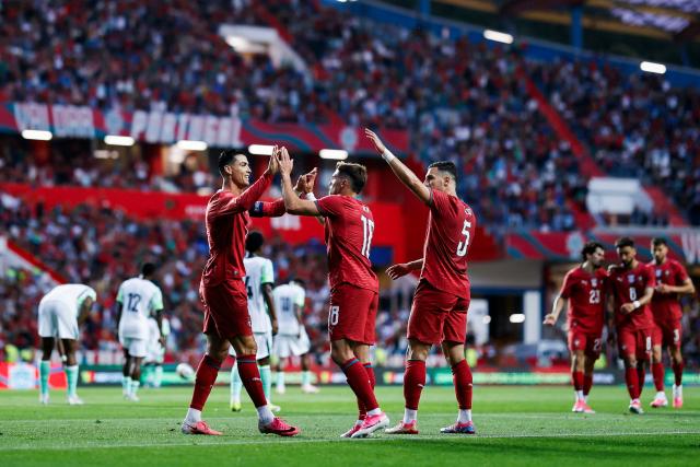 Portugal's midfielder #18 Pedro Neto (C) celebrates scoring the opening goal with Portugal's forward Cristiano Ronaldo (L) during the international friendly football match between Portugal and Nigeria at Magalhaes Pessoa Stadium in Leiria, on June 10, 2026. (Photo by FILIPE AMORIM / AFP)