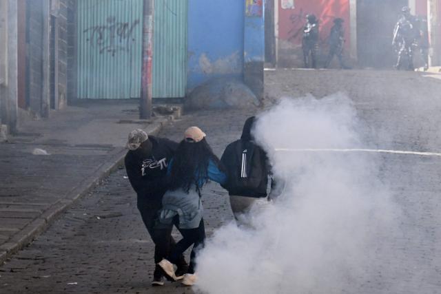People run from tear gas during a protest against the government of Bolivia's President Rodrigo Paz in La Paz on June 10, 2026. For weeks, protesters demanding that US-backed conservative President Rodrigo Paz's fledgling government address a deep economic crisis, while others called for his resignation, have marched and set up roadblocks, bringing Bolivia to a near standstill, driving up food and fuel prices and causing shortages of basic goods. (Photo by MARVIN RECINOS / AFP)