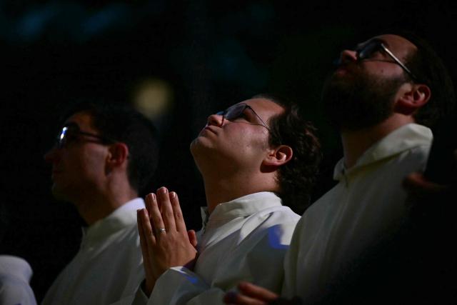 Faithfuls pray during the inauguration of the Jesus Christ tower by Pope Leo XIV, outside of the Basilica of the Sagrada Familia, in Barcelona, on June 10, 2026. Pope Leo XIV is visiting Spain June 6-12 with stops in Madrid, Barcelona, and the Canary Islands, where he will meet with migrants and organisations dedicated to helping them. (Photo by Stefano RELLANDINI / AFP)