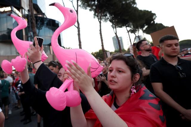 Protestors hold inflatable flamingos as they gather in front of the Albanian Prime Minister's Office to demonstrate against the construction on the southern coast of Albania of a luxury resort near a protected natural area, in Tirana, on June 10, 2026. Several thousand citizens have demonstrated in Tirana for more than a week to demand transparency around a tourist complex project allegedly linked to US President's son-in-law, Jared Kushner. The demonstrators argue that the estimated $1.2 billion project, led by Kushner and his wife Ivanka, will harm the environment, with plans for luxury hotels in the protected area of Vjosa-Narta on the southern coast. (Photo by Adnan Beci / AFP)