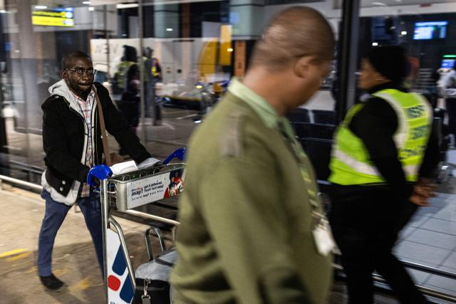 A Nigerian national, who will be part of the first evacuation flight for Lagos, is directed towards the entrance by a South African Border Management Authority official at the OR Tambo International Airport, in Johannesburg on June 10, 2026. The first batch of Nigerian nationals board an Air Peace Airlines evacuation flight chartered by the Federal Government of Nigeria, departing for Lagos amid a wave of xenophobic attacks in South Africa. Hundreds of anti-migrant protesters marched through a township outside Johannesburg on June 8, 2026, a day after South African President Cyril Ramaphosa pledged action against groups accused of fuelling xenophobic violence. South Africa has seen recurring bouts of anti-migrant violence, with protests intensifying this year after vigilante groups ordered undocumented foreigners to leave by June 30. (Photo by EMMANUEL CROSET / AFP)