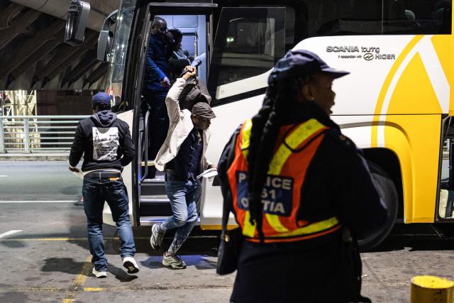 Nigerian nationals, who will be part of the first evacuation flight for Lagos, get off a bus at the OR Tambo International Airport, in Johannesburg on June 10, 2026. The first batch of Nigerian nationals board an Air Peace Airlines evacuation flight chartered by the Federal Government of Nigeria, departing for Lagos amid a wave of xenophobic attacks in South Africa. Hundreds of anti-migrant protesters marched through a township outside Johannesburg on June 8, 2026, a day after South African President Cyril Ramaphosa pledged action against groups accused of fuelling xenophobic violence. South Africa has seen recurring bouts of anti-migrant violence, with protests intensifying this year after vigilante groups ordered undocumented foreigners to leave by June 30. (Photo by EMMANUEL CROSET / AFP)