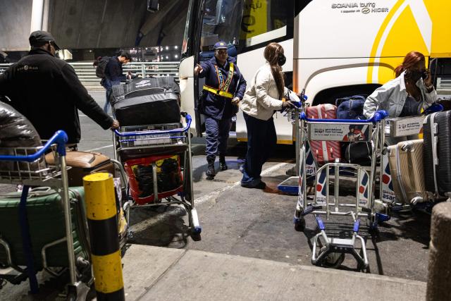 A South African Police Service (SAPS) officer directs Nigerian nationals towards the entrance at the OR Tambo International Airport, in Johannesburg on June 10, 2026, as the a first group of Nigerian nationals gets ready to board an evacuation flight for Lagos. The first batch of Nigerian nationals board an Air Peace Airlines evacuation flight chartered by the Federal Government of Nigeria, departing for Lagos amid a wave of xenophobic attacks in South Africa. Hundreds of anti-migrant protesters marched through a township outside Johannesburg on June 8, 2026, a day after South African President Cyril Ramaphosa pledged action against groups accused of fuelling xenophobic violence. South Africa has seen recurring bouts of anti-migrant violence, with protests intensifying this year after vigilante groups ordered undocumented foreigners to leave by June 30. (Photo by EMMANUEL CROSET / AFP)
