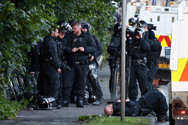 Police regroup as they block the road from protesters leading to a hotel previously believed to house migrants, in Glengormley, north of Belfast, Northern Ireland, on June 10, 2026. Northern Ireland braced on June 10 for a potential second night of violence directed at immigrants, following unrest that UK authorities say was stoked by far-right activists on social media after a brutal Belfast stabbing. (Photo by Henry NICHOLLS / AFP)