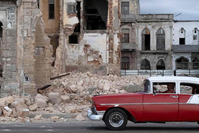 An old car drives past debris from a demolished house occupying part of the seaside promenade in the Centro Habana neighborhood, in Havana on June 9, 2026. The United Nations High Commissioner for Human Rights on June 8, 2026, urged the United States to "immediately" lift the sanctions that have been accumulating against Cuba since January. "Fuel restrictions imposed since early 2026 and the recent tightening of extraterritorial sanctions are directly harming Cubans, particularly the most vulnerable," Volker Turk said in a statement. (Photo by Pablo PORCIUNCULA / AFP)