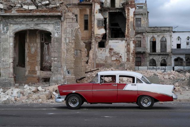 An old car drives past debris from a demolished house occupying part of the seaside promenade in the Centro Habana neighborhood, in Havana on June 9, 2026. The United Nations High Commissioner for Human Rights on June 8, 2026, urged the United States to "immediately" lift the sanctions that have been accumulating against Cuba since January. "Fuel restrictions imposed since early 2026 and the recent tightening of extraterritorial sanctions are directly harming Cubans, particularly the most vulnerable," Volker Turk said in a statement. (Photo by Pablo PORCIUNCULA / AFP)
