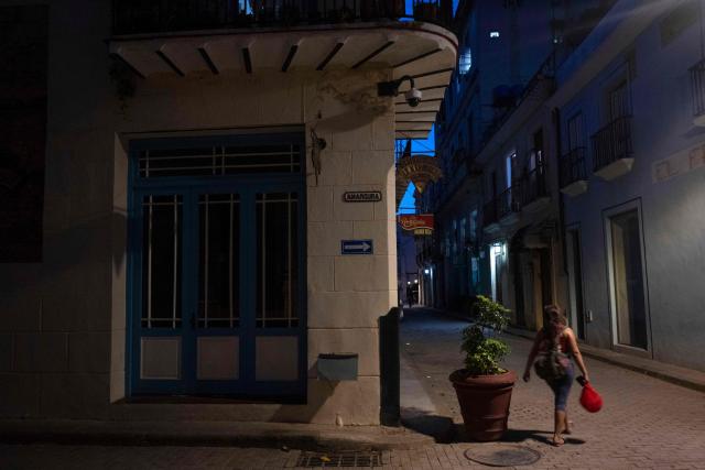 A woman walks through a place traditionally visited by tourists in Old Havana that appears empty due to a lack of visitors in Havana on June 9, 2026. The United Nations High Commissioner for Human Rights on June 8, 2026, urged the United States to "immediately" lift the sanctions that have been accumulating against Cuba since January. "Fuel restrictions imposed since early 2026 and the recent tightening of extraterritorial sanctions are directly harming Cubans, particularly the most vulnerable," Volker Turk said in a statement. (Photo by Pablo PORCIUNCULA / AFP)