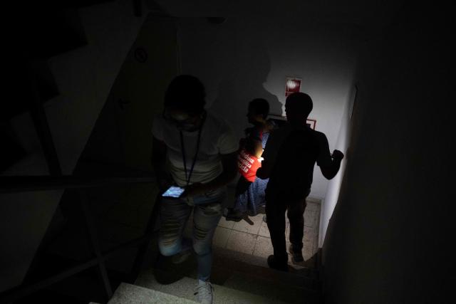 Employees walk down the stairs of a building in Old Havana during a blackout affecting much of the city on June 10, 2026. The United Nations High Commissioner for Human Rights on June 8, 2026, urged the United States to “immediately” lift the sanctions that have been accumulating against Cuba since January. “Fuel restrictions imposed since early 2026 and the recent tightening of extraterritorial sanctions are directly harming Cubans, particularly the most vulnerable,” Volker Tьrk said in a statement. (Photo by Pablo PORCIUNCULA / AFP)