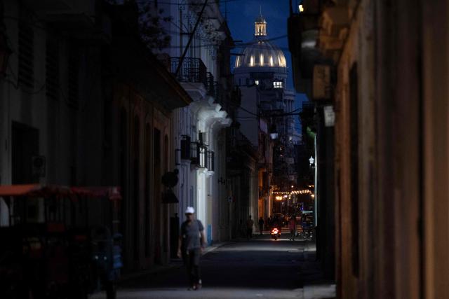 A man walks through a place traditionally visited by tourists in Old Havana that appears empty due to a lack of visitors in Havana on June 9, 2026. The United Nations High Commissioner for Human Rights on June 8, 2026, urged the United States to "immediately" lift the sanctions that have been accumulating against Cuba since January. "Fuel restrictions imposed since early 2026 and the recent tightening of extraterritorial sanctions are directly harming Cubans, particularly the most vulnerable," Volker Turk said in a statement. (Photo by Pablo PORCIUNCULA / AFP)
