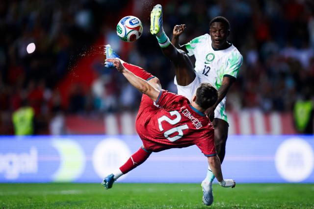 Portugal's forward #26 Francisco Conceicao and Nigeria's midfielder #12 Tochukwu Nadi fight for the ball during the international friendly football match between Portugal and Nigeria at Magalhaes Pessoa Stadium in Leiria, on June 10, 2026. (Photo by FILIPE AMORIM / AFP)