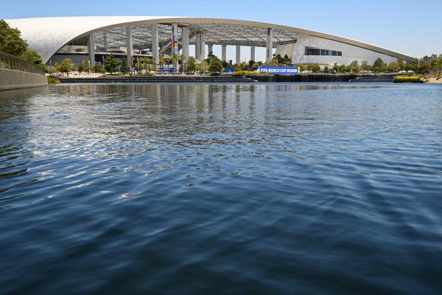 Los Angeles Stadium (temporarily renamed from SoFi Stadium) stands across Lake Park ahead of the 2026 FIFA World Cup in Inglewood, California on June 10, 2026. (Photo by Patrick T. Fallon / AFP)