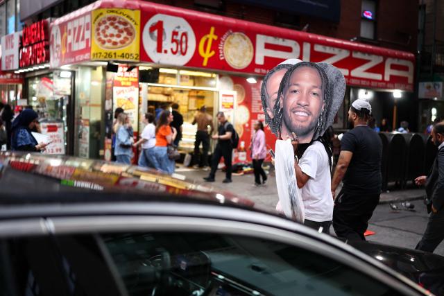 A fan holds cardboard cutouts of New York Knicks' player Jalen Brunson outside Madison Square Garden ahead of the NBA Finals game 4 between the New York Knicks and the San Antonio Spurs in New York on June 10, 2026. (Photo by CHARLY TRIBALLEAU / AFP)
