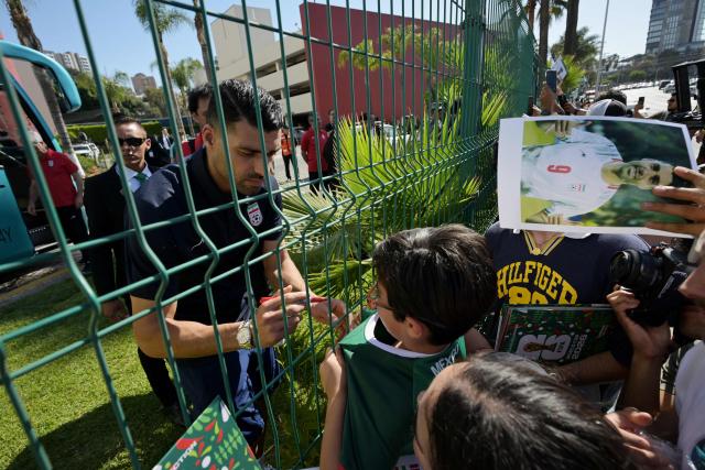 Iran's forward Mehdi Taremi signs autographs for a fan outside the Marriott Hotel before leaving for a training session in Tijuana, Mexico, on June 10, 2026, ahead of the 2026 FIFA World Cup football tournament. (Photo by Guillermo Arias / AFP)