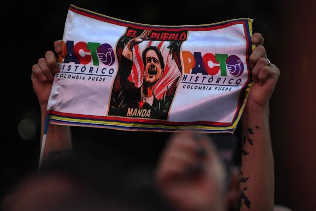 A supporter of Colombia's presidential candidate for the Pacto Historico party, Ivan Cepeda, holds up a banner of him during a campaign rally in Medellin, Colombia on June 10, 2026. Colombia will hold the runoff presidential election on June 21. (Photo by Jaime SALDARRIAGA / AFP)