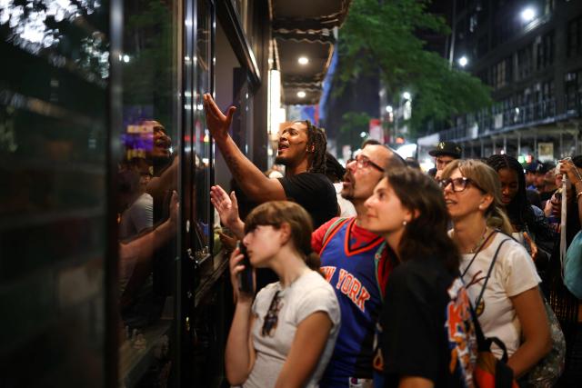 New York Knicks fans watch the game live through the windows of a bar outside Madison Square Garden during Game 4 of the NBA Finals between the New York Knicks and the San Antonio Spurs in New York on June 10, 2026. (Photo by CHARLY TRIBALLEAU / AFP)