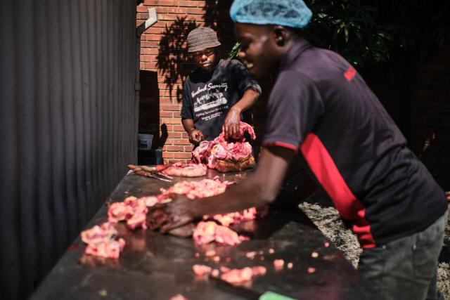 Kitchen staff prepare fresh ox-head meat at a traditional food kitchen in Bulawayo on May 15, 2026. In Zimbabwe, nutritionists warn that the shift away from traditional grains, legumes and leafy vegetables has fuelled persistent deficiencies in essential micronutrients such as iron, zinc and vitamin A. Scientists say poor nutrition is linked to one in five deaths globally, as fast food and ultra-processed meals steadily replace traditional diets across much of the world. (Photo by Zinyange AUNTONY / AFP)