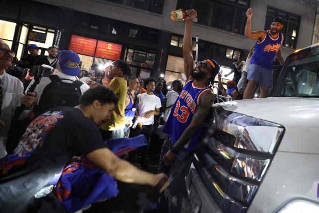 Knicks fans climb onto a truck in New York, on June 10, 2026 during game four of the NBA Finals between the San Antonio Spurs and the New York Knicks. (Photo by CHARLY TRIBALLEAU / AFP)