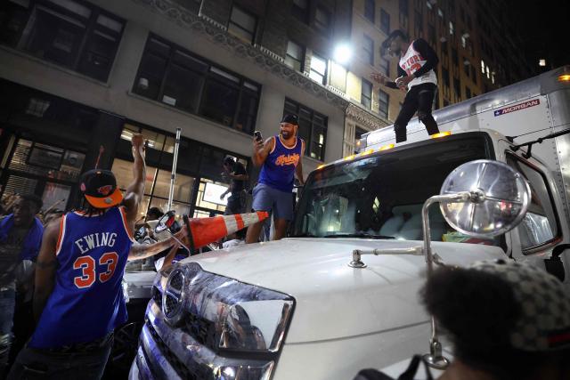 Knicks fans climb onto a truck in New York, on June 10, 2026 during game four of the NBA Finals between the San Antonio Spurs and the New York Knicks. (Photo by CHARLY TRIBALLEAU / AFP)