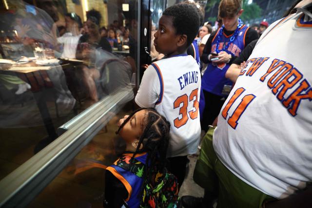 New York Knicks fans watch the game ona TV through the windows of a bar outside Madison Square Garden during Game 4 of the NBA Finals between the New York Knicks and the San Antonio Spurs in New York on June 10, 2026. (Photo by CHARLY TRIBALLEAU / AFP)
