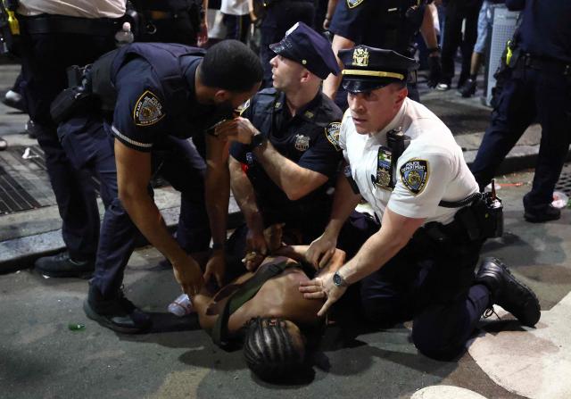 NYPD officers detain a man after scuffles outside Madison Square Garden, where New York Knicks fans gathered during Game 4 of the NBA Finals between the New York Knicks and the San Antonio Spurs in New York on June 10, 2026. (Photo by CHARLY TRIBALLEAU / AFP)