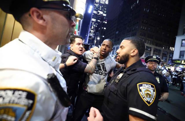 NYPD officers detain a man after clashes outside Madison Square Garden, where New York Knicks fans gather during Game 4 of the NBA Finals between the New York Knicks and the San Antonio Spurs in New York on June 10, 2026. (Photo by CHARLY TRIBALLEAU / AFP)