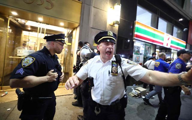 NYPD officers gestures after clashes outside Madison Square Garden, where New York Knicks fans gather during Game 4 of the NBA Finals between the New York Knicks and the San Antonio Spurs in New York on June 10, 2026. (Photo by CHARLY TRIBALLEAU / AFP)