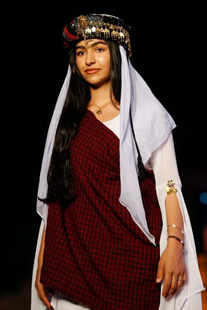 A Kurdish woman presents a traditional outfit during the 4th (Shal Shabek), Kurdish costume festival in the city of Zakho, in Iraq's northern autonomous Kurdistan region on June 10, 2026. (Photo by Safin HAMID / AFP)