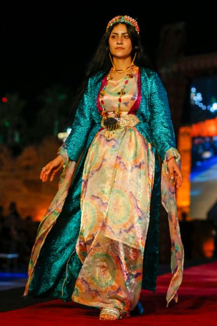 A Kurdish woman presents a traditional outfit during the 4th (Shal Shabek), Kurdish costume festival in the city of Zakho, in Iraq's northern autonomous Kurdistan region on June 10, 2026. (Photo by Safin HAMID / AFP)