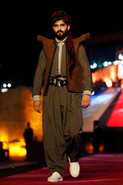 A Kurdish man presents a traditional outfit during the 4th (Shal Shabek), Kurdish costume festival in the city of Zakho, in Iraq's northern autonomous Kurdistan region on June 10, 2026. (Photo by Safin HAMID / AFP)