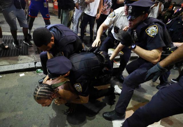 NYPD officers detain a man after clashes outside Madison Square Garden, where New York Knicks fans gather during Game 4 of the NBA Finals between the New York Knicks and the San Antonio Spurs in New York on June 10, 2026. (Photo by CHARLY TRIBALLEAU / AFP)