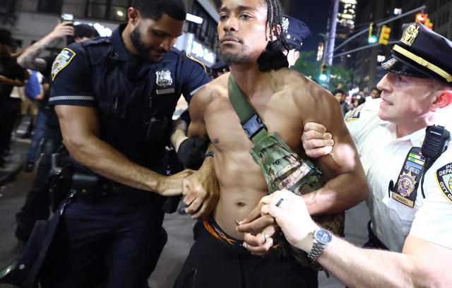 NYPD officers detain a man after clashes outside Madison Square Garden, where New York Knicks fans gather during Game 4 of the NBA Finals between the New York Knicks and the San Antonio Spurs in New York on June 10, 2026. (Photo by CHARLY TRIBALLEAU / AFP)