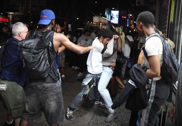 People fight in the street as New York Knicks fans celebrate after their team’s Game 4 victory over the San Antonio Spurs in the NBA Finals in New York on June 10, 2026. (Photo by CHARLY TRIBALLEAU / AFP)