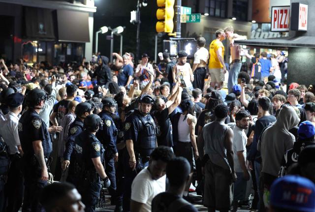 NYPD officers stand by as New York Knicks fans celebrate outside Madison Square Garden after their team’s Game 4 victory over the San Antonio Spurs in the NBA Finals in New York on June 10, 2026. (Photo by CHARLY TRIBALLEAU / AFP)