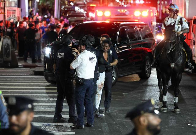 NYPD officers detain a woman after New York Knicks victory celebrations turned disorderly following the team’s Game 4 win over the San Antonio Spurs in the NBA Finals in New York on June 10, 2026. (Photo by CHARLY TRIBALLEAU / AFP)