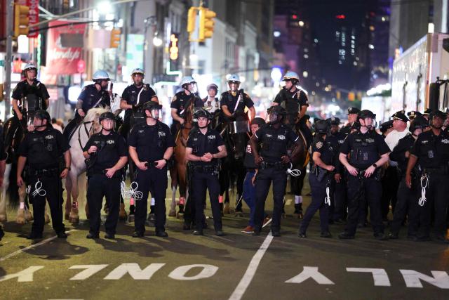 NYPD officers and mounted police attempt to disperse the crowd and secure the area after New York Knicks victory celebrations turned disorderly following the team’s Game 4 win over the San Antonio Spurs in the NBA Finals in New York on June 10, 2026. (Photo by CHARLY TRIBALLEAU / AFP)