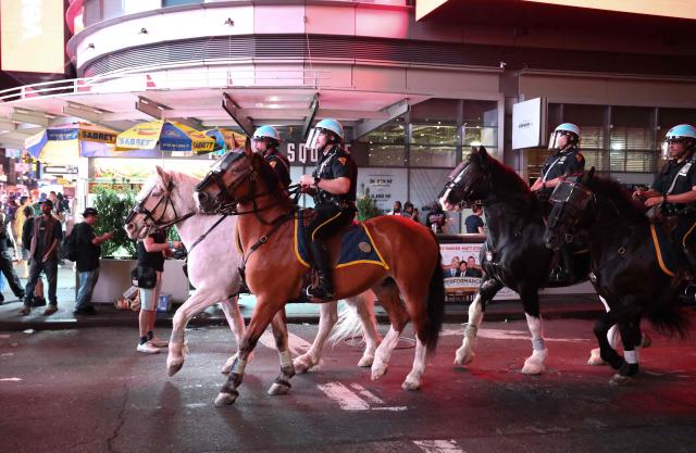 NYPD mounted police officers arrive as reinforcements after New York Knicks victory celebrations turned disorderly following the team’s Game 4 win over the San Antonio Spurs in the NBA Finals in New York on June 10, 2026. (Photo by CHARLY TRIBALLEAU / AFP)