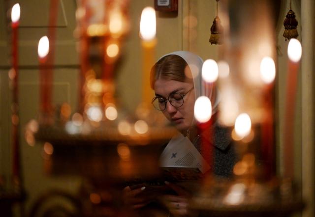 A Russian Orthodox believer prays during a service at the Pskovo-Pechersky monastery in the town of Pechory, some 50 kilometres outside Pskov, on April 19, 2026. (Photo by Olga MALTSEVA / AFP)