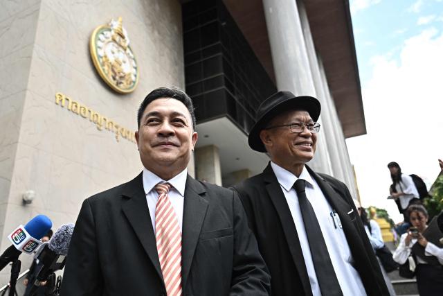 Lawyer Choochat Kanpai (L), representing bombing suspects Bilal Mohammed and Yusufu Mieraili, stands outside the Bangkok South Criminal Court in Bangkok on June 11, 2026, after the verdict for the Erawan Shrine bombing on August 17, 2015. Two Uyghur men were sentenced to death on June 11 for carrying out a 2015 attack on a Bangkok shrine that killed 20 people, a long-awaited verdict in Thailand's deadliest bombing case. (Photo by Lillian SUWANRUMPHA / AFP)