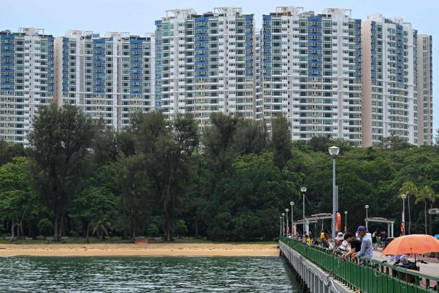 Anglers fish from a jetty at East Coast Park in Singapore on June 11, 2026. (Photo by Roslan RAHMAN / AFP)