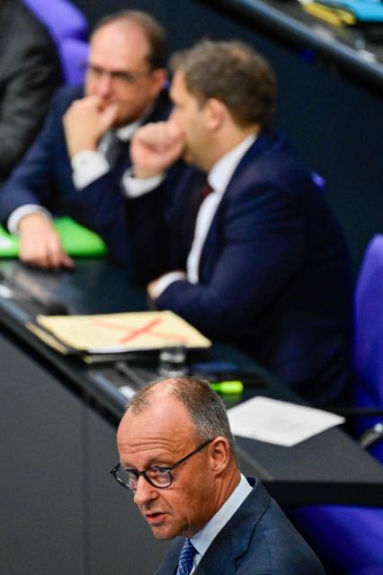 German Chancellor Friedrich Merz speaks as German Finance Minister and Vice Chancellor Lars Klingbeil (C) and German Interior Minister Alexander Dobrindt (R) confer at the German Bundestag (lower house of parliament) on June 11, 2026, ahead of an EU summit. (Photo by John MACDOUGALL / AFP)