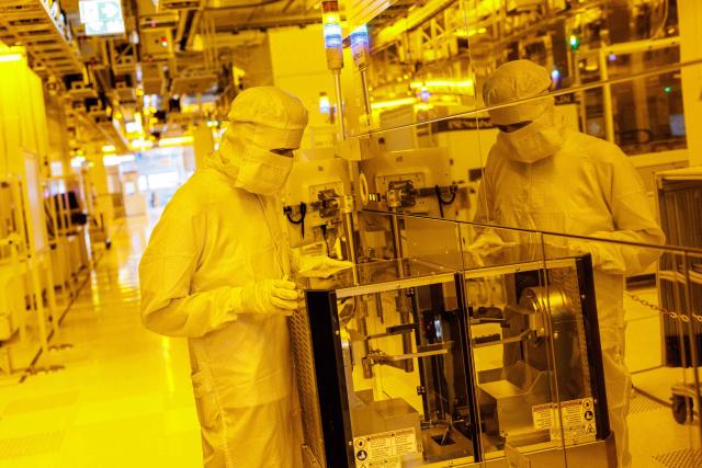 An employee works at the clean room for 300mm wafer manufacturing at the plant of German semiconductor manufacturer Infineon Technologies AG in Dresden, eastern Germany, on June 10, 2026. On July 2, 2026, Infineon will officially open its Smart Power Fab that manufactures power semiconductors as well as analog/mixed-signal-components in Dresden. With an investment of five billion euros, the new facility represents the largest single investment in Infineon's history. (Photo by Jens SCHLÜTER / AFP)