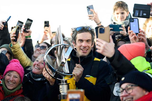 (FILES) French skipper Charlie Dalin poses among members of the public with his trophy after winning the 10th edition of the Vendee Globe around the world monohull solo sailing race, in Les Sables-d'Olonne, western France, early on January 14, 2025. French offshore sailor and Vendee Globe 2024/2025 winner Charlie Dalin has died in Quimper, western France, aged 42, from cancer, his family announced on June 11, 2026. (Photo by Loic VENANCE / AFP)