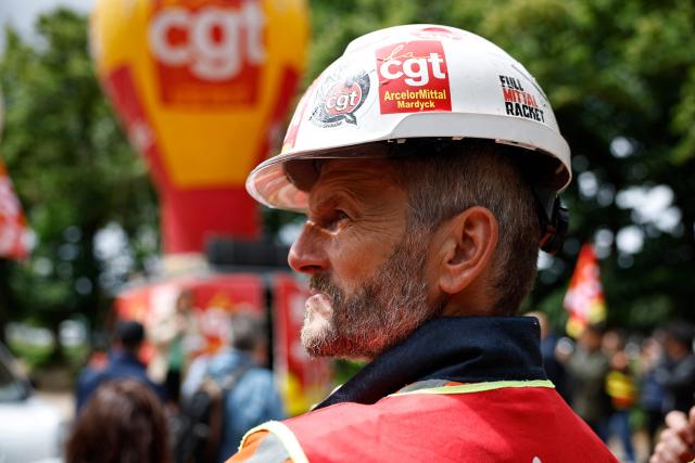 An ArcelorMittal worker looks on at the esplanade des Invalides outside the National Assembly, France's lower house of parliament, during a demonstration in support of the nationalisation of steelmaking giant ArcelorMittal, called by the General Confederation of Labour (CGT), as the bill comes before the National Assembly in Paris on June 11, 2026. (Photo by SIMON WOHLFAHRT / AFP)