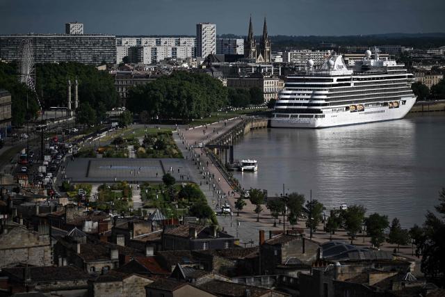 This photograph taken from the top of the restored Saint-Michel bell tower shows a cruise ship docked at the Bordeaux port along the Garonne river in Bordeaux, southwestern France on June 11, 2026. The 114-meter high Saint-Michel, built at the end of the 15th century, is set to reopen to the public on June 13 following five years of restoration. (Photo by Christophe ARCHAMBAULT / AFP)
