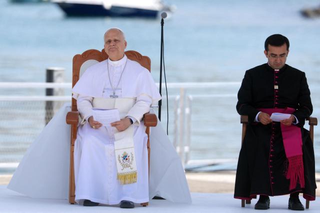 Pope Leo XIV (L) attends a meeting with organizations working with migrants in the port of Arguineguin on the Canary Island of Gran Canaria, a place accustomed to the arrival of migrants, on June 11, 2026. Pope Leo XIV is visiting Spain June 6-12 with stops in Madrid, Barcelona, and the Canary Islands, where he will meet with migrants and organisations dedicated to helping them. (Photo by Pierre-Philippe MARCOU / AFP)